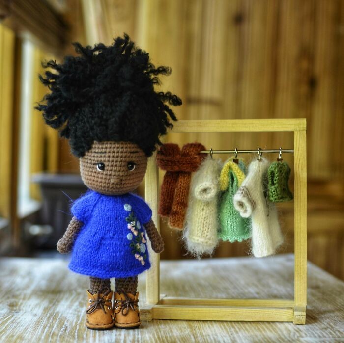7. "Маленькая кукла с набором одежды и деревянной вешалкой"