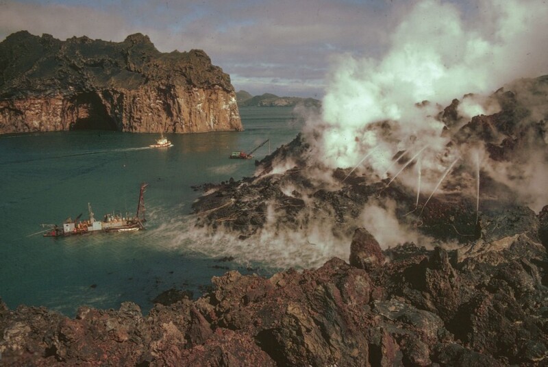 Январь 1973 года. Извержение вулкана на острове Хеймаэй в Исландии. Пожарные охлаждют поток лавы, чтобы защитить гавань. Фото Ajnj Fred Ihrt.