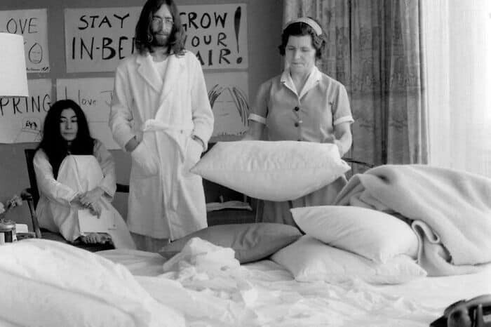 Джон Леннон и Йоко Оно ожидают, пока горничная заправляет их кровать, 1969