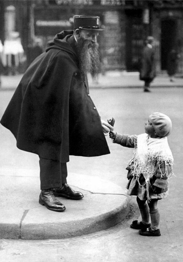 13. 1929. Маленькая девочка вручает лилии дежурному полицейскому у ворот Сен-Дени в Париже