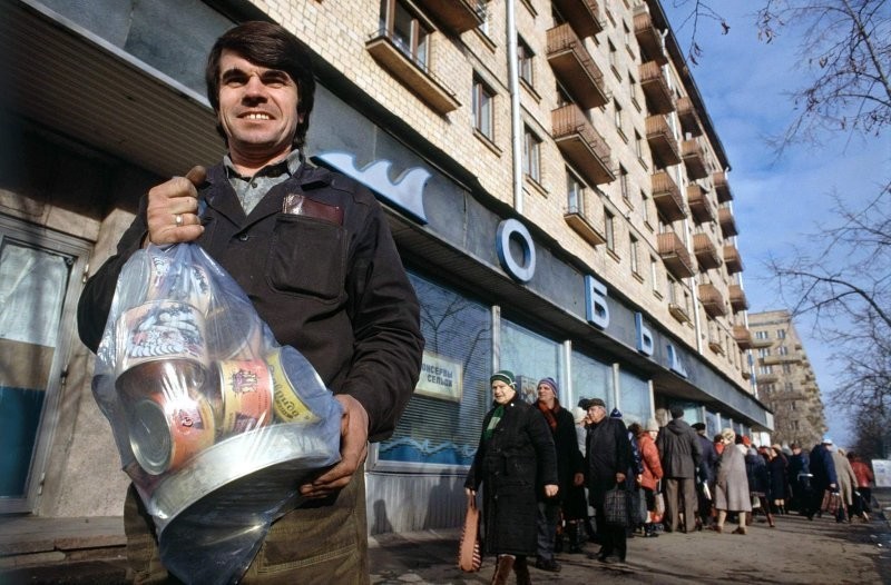 Богатый улов, 1990 год.  "Экономический кризис в Москве. Москвич демонстрирует несколько банок с едой, которые он смог получить, прождав два часа перед государственным рыбным магазином."