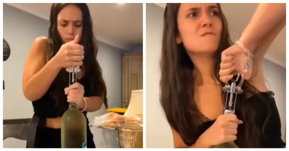 Девушка пытается открыть бутылку штопором