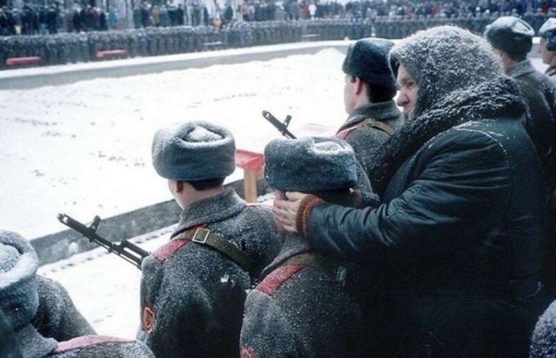 10. Бабушка греет уши своему внуку во время принятия им военной присяги, Волгоград, 1994 год