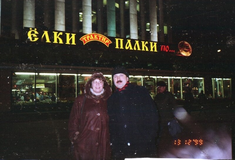 Семейная пара фотографируется на фоне фастфуда «Трактир Елки–палки», 13 декабря 1999 года, Москва.  