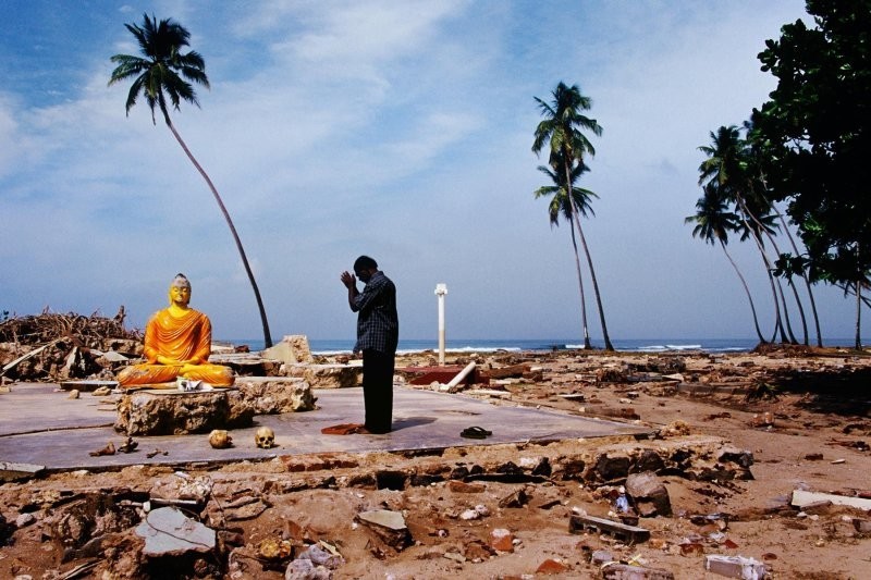 Мужчина молится на месте храма, который был смыт цунами, Катхалуве, Шри-Ланка, 2004 год