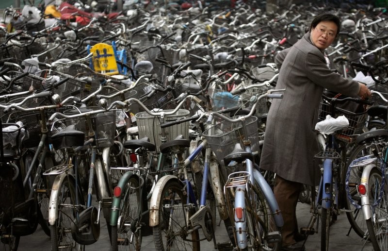 3. Женщина забирает свой велосипед со стоянки возле станции метро в Пекине