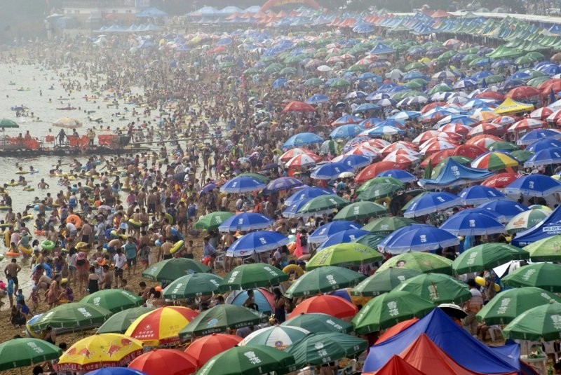 13. Люди на пляже в Даляне, провинция Ляонин, спасаясь от летней жары