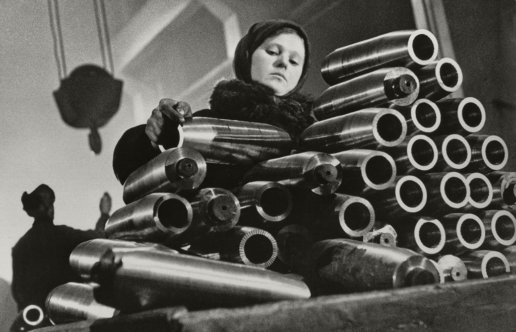 Девочка укладывает болванки снарядов на ленинградском заводе, 1942