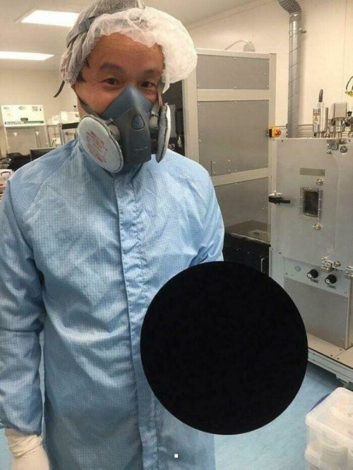 Ученый держит мяч, покрытый материалом Vantablack – самым темным материалом из известных науке. 
Кажись держит в перчатке-невидимке.