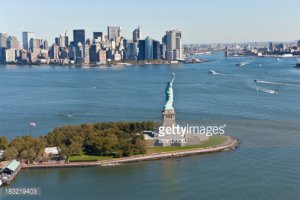 Я не буду спорить. Я лучше покажу фотографии статуи.
Первая фотография показывает насколько далеко Статуя от Манхеттена с которого плавают паромы и прогулочные катера. Там (на Манхеттене) конечно есть метро, но оно находится глубоко под землей.
Вторая фотография показывает как далеко находится берег с ракурса, который на твоем рисунке (а статуя смотрит на Бруклин).
А вопросы твои почему-то мне напомнили информацию, которую печатают в рекламных буклетах для туристов. Тем более, что с аэропорта намного удобней доехать до точки назначения на тахи/кар-сервисе. Поездка на общественном транспорте займет кучу времени и нервов.
Но если кому-то и прийдет в голову с аэропорта поехать сразу на небережную не заезжая в гостиницу или место, где человек будет ночевать, то наиболее быстрый способ на общественном транспорте будет (из JFK): Сесть на Air Train ($5), потом сесть на линию А (еще $2.75), а потом на станции Jay St Мetro Tech пересесть на линию R и доехать до Whitehall St South Ferry. Есть вариант дешевле: из аэропорта сесть на автобус, например на Q10, доехать до Ozone Park, пересесть там на линию А, ну а дальше как в варинте 1. стоимость такого проезда будет $2.75. Но, повторяю так извращаться мало кто захочет, проще и удобней на доехать на такси. Вторым аэропортом Laguardia я не пользовался, так что про него говорить не буду.