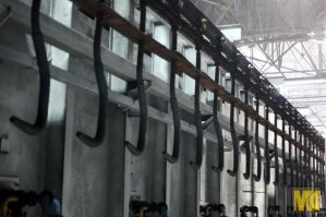 Прям ностальгия.
Я проходил практику в 2000 на Выксунском колёсопрокатном цехе.
Практически один в один.
Из выбитых прессом середин заготовок получались не хилые гантели.
А из "чешуи" это на закалочной линии были такие листы 10 мм толщиной получались отличные ножи, топоры, мечи, причём разрубали гвоздь на ура без зазубрин.
На фото видны эти листы. На этих крюках происходит закалка колёс в печи.