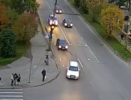 для проскакунов:  
6.2. Круглые сигналы светофора имеют следующие значения:
ЗЕЛЕНЫЙ СИГНАЛ разрешает движение;
ЗЕЛЕНЫЙ МИГАЮЩИЙ СИГНАЛ разрешает движение и информирует, что время его действия истекает и вскоре будет включен запрещающий сигнал (для информирования водителей о времени в секундах, остающемся до конца горения зеленого сигнала, могут применяться цифровые табло);
ЖЕЛТЫЙ СИГНАЛ запрещает движение, кроме случаев, предусмотренных пунктом 6.14 Правил, и предупреждает о предстоящей смене сигналов;
ЖЕЛТЫЙ МИГАЮЩИЙ СИГНАЛ разрешает движение и информирует о наличии нерегулируемого перекрестка или пешеходного перехода, предупреждает об опасности;
КРАСНЫЙ СИГНАЛ, в том числе мигающий, запрещает движение.

6.14. Водителям, которые при включении желтого сигнала или поднятии регулировщиком руки вверх не могут остановиться, не прибегая к экстренному торможению в местах, определяемых пунктом 6.13 Правил, разрешается дальнейшее движение.
Пешеходы, которые при подаче сигнала находились на проезжей части, должны освободить ее, а если это невозможно - остановиться на линии, разделяющей транспортные потоки противоположных направлений.

на видео явно видно, что он мог 10 раз остановится, но он решил влить 0,5л топлива в двигатель (аж черный дым видно) и резко ускорится...
на первом фото видно как (уже горит желтый) все едут медленно и перед джипом поворачивают две машины
на втором фото уже красный и джип дает газу, аж глушитель рвется (ну так как это же джип). 
При этом я уверен, что и двухколесный выехал на перекресток на красно желтый (всегда есть пауза в 1-2 сек).
По человечески и ПДД (ИМХО) виновен джип...