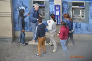 Цыгане помогают Мужчине получить деньги в Банкомате.
Когда карточка вставлена и набран Пин-код, начинают шуршать деньги, Терпилу отвлекают и забирают деньги, сразу передавая их подельнику. Если поймают, у него денег нет. Мужчина девушку бить не будет же.