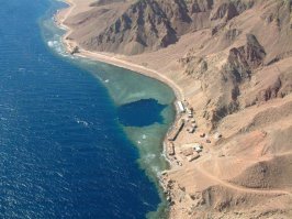 Еще одно интересное местечко
На побережье Красного моря севернее Дахаба находится Голубая дыра (Blue Hole) — одно из лучших мест на Синае и опаснейшее место для дайверов. Голубая дыра представляет собой вертикальную пещеру, уходящую в глубину Красного моря на 100 метров, окруженную коралловыми рифами. Как образовалась эта отвесная пещера, диаметром не менее 50 метров, геологи точно объяснить не могут. Туристы устремляются сюда, чтобы заглянуть в бездну с борта прогулочного катера, а самые смелые погружаются под воду, стремясь увидеть своими глазами, почувствовать завораживающий призыв бездны. Оттолкнувшись от края пещеры, дайвер устремляется в темноту. Другое название этого места — Кладбище дайверов, неслучайно. Маршрут погружения, не отличающийся сложностью, забрал более сотни жизней.
Пэ эс: на видео чемпион мира по фридайвингу Гийом Нери ныряет в Голубую дыру