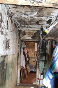 Дом аварийный, спору нет... Но, твою же мать! Пожар произошел 8 лет назад, и, судя по фото, никто за это время даже не удосужился устранить хотя бы видимые его последствия. Так и живут в этом говне, хотя наличие вещей говорит о том, что коридор активно используется.