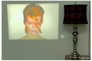 вот эта фотография  - фейк . с телефона взятая картинка потеряет яркость так, что ее видно будет только в темноте 
здесь же освещенная комната. картинка - спроецирована с обычного бытового проектора .