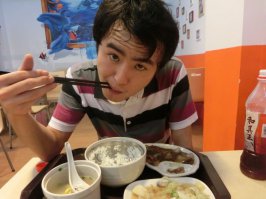 "51 Щеджан. Ужин, китайский фаст-фуд. Кукурузный суп, рис пресный, капуста, мясо, стоимость 100 р. Обратите внимание как Щеджан держит палочки. Кстати Щеджан никогда в жизни не пользовался вилкой или ложкой или ножом"

А теперь два вопроса: 
- Удобно ли есть суп палочками?
- И что за девайс в таком случае у Щеджан в тарелке с кукурузной похлебкой?