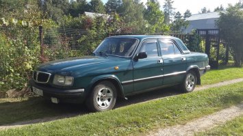 Пробег 75 000 - 79 999 км, 2.4 МТ, бензин, седан, цвет зелёный. Продаю свою волгу! Покупка, прямо скажем, сомнительная, но зато и цена — чисто символическая. 30 тысяч рублей и крейсер ваш! Год выпуска 2005, состояние противоречивое. Пробег обозначен на табло как 72000, но под этим стоит понимать 172000. А если совсем честно, то 272000. До сих пор не понимаю как она смогла проехать такое расстояние. 
Самое главное, аппарат на ходу! По городу никаких проблем (кроме того, что без кондиционера летом возникает ощущение как будто машина горит). Рвёт со светофора многие иномарки (особенно те, которые не подозревают, что участвуют в состязании). По трассе тоже нормуль. Какую скорость вам удастся на ней развить, зависит только от вашего инстинкта самосохранения. Лично я в те редкие разы, когда разгонял ее до 180, ловил себя на том, что не моргаю, не шевелюсь и практически не дышу.
У левой двери есть сгнивший участок из которого торчит полиэтилен. Очень помогает обнаруживать автомобиль на больших парковках и придает зверюге неповторимую индивидуальность. По кузову — есть некоторые участки, которые можно считать нормальными.
Внутренняя отделка салона выполнена по чьей–то непостижимой прихоти с использованием линолеума. С этим придется жить. Глубоко в водительском кресле есть какая–то очень острая деталь, которая иногда больно впивается в поясницу. Я так и не разобрался, что это за деталь, почему она там и как такое вообще может быть.
Есть кнопка включения кондиционера, это единственная деталь кондиционера которая дожила до наших дней. Так же имеется бортовой компьютер, подозреваю что именно его искусственный интеллект (а не Вы) решает когда машине завестись, а когда заглохнуть.
Печка — пламя Саурона — работает зимой так, что мама не горюй. Но, к сожалению, горячий воздух подтравливает снизу, и летом, когда печка выключена, если жать больше 110 по трассе в сандалях, то сильно обжигает пальцы на правой ноге. Так что летом на правую ногу лучше одевать кроссовок...
В машине последние полтора месяца не курил. А до этого курил, очень много. Но не больше, чем предыдущий хозяин и его многочисленные друзья — одновременно, все вместе, зимой, с плотно закрытыми стеклами. Потолок нехарактерно серого цвета не позволит этого скрыть.
Очень большой плюс - глушитель отсутствует, издает рев, как из преисподней! В связи с чем от страха обсираются даже мужественные байкеры и держатся от тебя подальше, что в свою очередь обеспечивает комфортную езду.
Один из важнейших плюсов этой машины, это то что ее категорически не хотят останавливать инспектора ДПС. И даже когда ты проезжаешь перед ними с не пристегнутыми ремнями и выключенным ближним светом - они лишь проводят тебя сочувствующим взглядом... В чем загадка, я так и не понял. Так же ее очень боятся подрезать дорогие и не очень иномарки...
В связи с вышеперечисленным, иногда чувствуешь себя как в президентском кортеже, пока острая