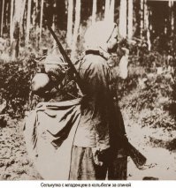 Жительница Западной Сибири, народность селькупы, с переноской для ребёнка. Таскали с собой по тайге дитё. На привале конструкция позволяла подвешивать на дерево и превращать в качающуюся люльку.