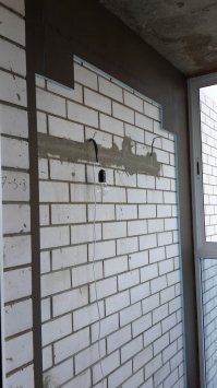 Поведаю мою грустную историю... решил я сделать из балкона этакую каменную пещерку для приняться утреннего кофе и вечерних возлияний. Так как балкон холодный, а утеплять его не особо хотелось, то решили обложить керамогранитом, а чтоб было не совсем мрачно - сделать нишу из светлого кирпичика. 
Для создания рельефа использовал панели из экструдированного полисторола с подготовкой для укладки плитки (клеится на жидкие гвозди).
Основная плитка - рифленая, плиткорезом не режется, пришлось все перепилить алмазным кругом, свист стоял на весь двор! С кирпичиком, как оказалось, меня кинули на коробку (4 коробки навалом, такой же кривой и с "облоем"), но благо все ушло в "0" и осталось 4 пол-плитки, да, ее тоже пилил алмазом.