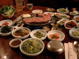 в корейской еде самое главное это подача. приносят кучу всего в маленьких тарелочках. и само корейское барбикю надо готовить самому. в хороших ресторанах приносят большое глиняное ведро с углями, в галимых ресторанах електрическая барбикюшница. Сидят часами на полу за низким столом. Самое лучшая корейская барбикю получается из мраморного мяса из японского города Кобе.