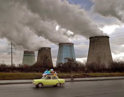 ... вот посмотрит какой нибудь безмозглый зритель и скажет, ах, какой контраст, жизнь на фоне дымящих труб 
На самом деле на фото запечатлены градирни, которые используются для охлаждения сбрасываемой из ТЭЦ воды, и из них идет обыкновенный пар :) Пар это вода в газообразном состоянии, и она так же безвредна как любая другая вода, включая ту которую мы пьем  :)