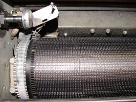 это напечатано именно на такого вида принтере. Сам ещё застал такие. "Повезло" поработать ))) Там сначала раскручивается ротор (или барабан). Барабан набирается дисками, где по периметру расположены все буквы и цифры алфавита. Таких дисков было разное количество. Количество молоточков было равно количеству дисков. А молоточек "стучит" только тогда, когда "подошла" нужна буква. Треск очень сильный. Но печаталось быстро очень (строка за раз почти). Да и количество листов печати в день тоже было очень большое. Практически безотказные, только ленточку нам меняли.