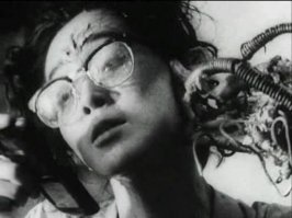 Тэцуо — железный человек / Tetsuo — The Ironman (1988).
Технофетишист пытается увеличить свою ногу, вставив в нее кусок металла — труба длиной 30 сантиметров. И… он снимает бинты с ноги и его самодеятельная хирургия не удалась! Он кричит и убегает… Тем временем некий бизнесмен едет в машине и они встречаются в результате автокатастрофы. Это начало конца для нашего бизнесмена, который медленно превратится в груду металлолома.
На IMDB присвоен статус хоррора.