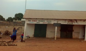 Гамбия считается президентской республикой. Президент Гамбии носит официальный титул: Его превосходительство президент шейх профессор аль-хаджи доктор Айя Абдул-Азиз Джамус Джункунг Джамме. Он начал карьеру на госслужбе в качестве начальника президентской охраны и стал президентом, совершив в 1994 году бескровный военный переворот с пятью своими товарищами- молодыми лейтенантами (заговорщикам в то время было от 20 до 30 лет). Айя Джамме вошел в книгу рекордов Гиннеса как самый молодой президент (ему было 29 лет).

Президент Гамбии отличается экстравагантностью. В 2010 году он объявил о желании стать королем, заявил, что обладает сверхъестественными способностями, пообещал убить всех оставшихся в живых геев, а заодно и всех правозащитников. Годом ранее, после того как Президент обвинил колдунов вуду в смерти своей тети, в стране развернулась охота на ведьм. Дошло аж до выступления в ООН защиту обвиненных в колдовстве и замученных тысяч людей.

На фото пан-африканский бизнес-центр и видео клуб.