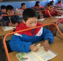 В Китае, город Ухань, всерьез озадачились проблемой ухудшения осанки и зрения у школьников, поэтому один из классов оборудовали экспериментальными партами со специальными перекладинами. Металлическая труба следит за осанкой учеников и не дает склониться над тетрадью слишком низко. Может быть, выглядит глупо, но ведь работает!