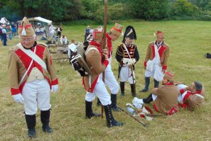 При Наполеоне ведь никакого эфира не было. Деревянный кляп в зубы плюс стакан водки внутрь. Вот и вся анестезия. Тем не менее, многие пациенты умирали от болевого шока. Английский хирург Листон считал, что избежать шока можно только скоростной операцией. Он доводил свою скорость перепиливания кости до нескольких секунд! 
Французские санитары, например, выносили из боя раненых не обращая внимания на их национальность или принадлежность. Хотя бы потому, что не разбирались в национальностях своей же армии. Так и русские попадали на медпункты французов.
Пациентов встречал дежурный хирург, который осматривал ранения и определял их тяжесть. Потом он мелом или углём ставил знаки на их мундирах для главного хирурга. Мелом, если мундир темный, углём - если светлый.
У хирургов были специальные приборы для извлечения пуль из раны. Так что почему тут решили ампутировать ногу, сказать сложно. В то же время, из-за огромного количества ранений в время битвы, ампутация была единственным способом сохранить больному жизнь. Хотя, в другое (мирное) время, многим раненым можно было бы сохранить их конечности.
Военные хирурги, по праву считались лучшими. Потому что лечение раненых солдат, давало им фантастическую практику...
На фото санитары и хирург французской армии.