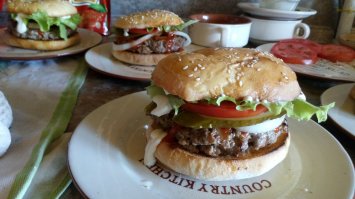 1. яйцо не надо. для бургера фарш делается 2 части мякоти 1 часть жира и вымешивается - от рук жир размягчается и фарш делается пластичный. затем котлетки формируются и охлаждаются в холодильнике минимум 30 мин. жарить на сухой сковороде.
2. весь это рецепт неверный - начиная с зажарки булок в масле, заканчивая размером котлеты и порядком сбора. а уж соус из майонеза и кетчупа - просто за гранью добра и зла.
в сети есть очень хорошие видеорецепты по бургерам. начиная с булочек. 
да - булочки лучше печь самим. покупные слишком сладкие и рыхлые.