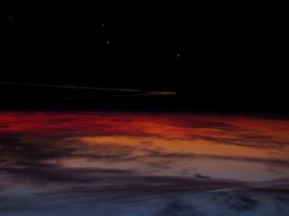 Похоже на космос: поверхность планеты, комета, звезды...
А на самом деле перевернутое фото: ранний рассвет, река, уличные фонари.