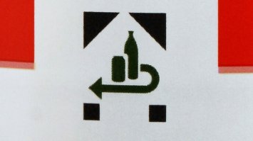 Не все пластиковые бутылки принимают такие автоматы. Только те, на которых стоит такой символ. При попадании пластиковой бутылки в такой аппарат, сначала считывается с неё этот символ, чтобы понять сдаётся ли эта тара или нет. Если нет такой, то в мусор её. С тех бутылок, которые не сдаются, не берут соответственно тару при покупке товара. Потом пластиковые отсеиваются влево или вправо прям в автомате и там дробятся на мелкие кусочки в большой чан под автоматом. И идут на завод по переработки этой массы. Стеклянные идут дальше по ленте и скапливаются в конце этой ленты на столе. Потом рабочие их по ящикам раскладывают. Как всё сдал, получил чек и можешь закупится что хочешь и на кассе отдашь чек и тебе разницу товара пересчитают. Или просто отдал чек и получил стоимость тары назад. Вот примерно так работает автомат