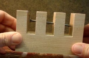 Вот с этим как раз понятно. Деревяшка выпиливается такой формы, затем несколько часов варится в воде, пока древесниа не станет мягкой, так, чтобы можно было крайние брусочки немного раздвинуть, затем бормашиной или маленькой дрелью делаются отверстия и вставляется гвоздь. Затем вся конструкция сушится, шлифуется и готова головоломка.