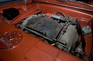 В 1963 году "Chrysler" стал первым в мире автопроизводителем, запустившим газотурбинные автомобили в серийное производство. Chrysler Corp. развернула уникальную программу под лозунгом «dream car в жизнь». Впервые в истории начался (мелко)серийный выпуск «автомобиля мечты» под говорящим названием Chrysler Turbine: легковушка с газотурбинным двигателем. Не только (и не столько) для выставок и демонстраций, сколько для повседневной эксплуатации. По замыслу, экспериментальная модель строилась в 55 экземплярах, из которых полсотни предназначались к раздаче в пользование американским автомобилистам по всей стране.
Как выбирали счастливых участников масштабного эксперимента — отдельный разговор. Так или иначе в октябре 1963 м-р Lynn A.Townsend, тогдашний президент Chrysler Corp., лично вручил ключи от новенького Chrysler Turbine первым пользователям – рядовой семье из чикагского пригорода. Процесс пошел. По программе, каждый из участников эксплуатировал машину в течение трех месяцев, а затем передавал ее очередному. Всего в эксперимент вовлекались две сотни автомобилистов. В Chrysler Corp. рассчитывали получить неоценимые сведения об эксплуатационных качествах «турбинной» легковушки – в условиях, приближенных к боевым. А также проверить реакцию потенциальных покупателей на непривычное транспортное средство – и оценить его рыночный потенциал.
Прогрессивная турбина вместо безнадежно устаревшего д.в.с. – вот ведущая идея крайслеровского dream car образца 1963. И в самом деле под капотом размещался газотурбинный двигатель (уже IV поколения) с вращающимися регенераторами тепла отработанных газов. Их температура на выхлопе падала до каких-то 245о C, — то есть, тепловая энергия утилизировалась довольно глубоко. Компактный агрегат весил 185+ кг и стыковался с 3-скоростным «автоматом» TorqueFlite (без гидротрансформатора, надобность в котором отпала в силу 2-вальной конструкции турбины).
Объявленная максимальная мощность агрегата (SAE «нетто») – 130 л.с. при 3600 оборотах выходного вала. То есть, сама-то вторичная (тяговая) турбина крутилась при максимальной мощности на 44600 мин-1, однако обороты понижались встроенным понижающим редуктором – до обычного в легковом автомобилестроении уровня («отсечка» на 4680 мин-1). Не сказать, что турбина отличалась выдающейся мощностью (тогда уже делали литражные «восьмерки» и на 400 сил – «брутто»). Зато крутящий момент она выдавала (на выходном валу) очень неслабый — за 575 Нм. Причем прямо от 0 оборотов, так что на разгонную динамику Chrysler Turbine никто не жаловался.
Мощная тяга транслировалась на неразрезный ведущий мост, подвешенный на продольных листовых рессорах. Передняя подвеска – на двойных поперечных рычагах, стандартная для американской легковушки тех лет ходовая. Узенькие (по нынешним понятиям) покрышки с диагональным кордом – и барабанные тормоза «по кругу». Рулевой механизм «винт-шариковая гайка» с гидроусилителем – все как у всех в начале 60-х. Так что Chrysler Turbine представлял собой пеструю мозаику передовых и традиционных (а где-то даже устаревших) технических решений, осторожное продвижение.
Как обычно для газовых турбин, крайслеровский агрегат оказался по-настоящему многотопливным: он успешно работал на неэтилированном бензине и авиационном керосине. И даже на растительном масле, хотя участникам эксперимента рекомендовали стандартное дизтопливо. Газотурбинный агрегат работал исключительно надежно и не доставлял добровольцам особенных хлопот.
Программа благополучно завершилась в начале 1965, после чего полсотни «турбинных» легковушек отправили на слом. В течении трех лет на этих автомобилях поездило около 200 человек, преимущественно проверенных клиентов фирмы, которые и вынесли неутешительный вердикт. Да, экзотичный мотор "Chrysler Turbine Car" превосходен по характеристикам. Он настолько тяговит и высокооборотен, что нет нужды в КПП — двигатель вращает ведущие колеса напрямую. Увы, но газовая турбина свистит как Соловей-разбойник, что невыносимо в дальних поездках. Второй недостаток — непомерный расход топлива, составлявший порядка 24 л /100 км. Чудовищный аппетит для относительно небольшой машины. В итоге программу газотурбинных автомобилей закрыли.
