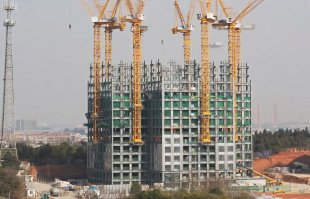 Там кран строит другой кран опираясь на уже построенный каркас здания при помощи других кранов. Либо один кран который умеет модульно наращивать сам себя :)