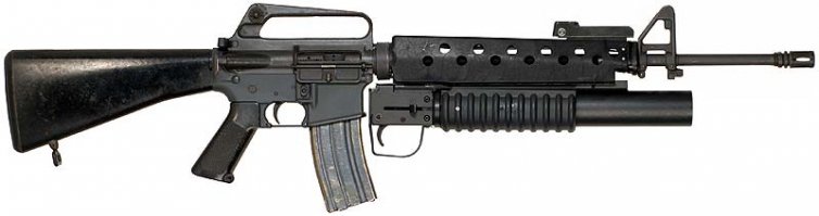 В руках у Тони штурмовая винтовка Colt M16A1 с подствольным гранатометом! 
Ну никак ни Томми-ган. Разница слишком уж очевидна.