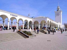 Сочинский вокзал - младший брат, а не близнец.
Симферополь. Слева направо: пригородные кассы, здание вокзала с итальянским двориком, арочные своды выхода к поездам/в город, башня часов, ДК железнодорожников, троллейбусные кассы и т.д.