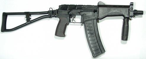 Есть и другие интересные вещи. Только широкого применения они не нашли...

Возможность скрытой переноски оружия для спецподразделений очень важна. Поэтому появляются специальные разработки, из-начально ориентированные на скрытую переноску. К такому типу оружия относится СР-3 "Вихрь".

Автомат был разработан в начале 1990-хх годов в ЦНИИ Точного Машиностроения (г. Климовск). Работы по созданию нового автомата и совершенствованию конструкции велись до 1994 года. Наибольшую роль в его создании сыграли конструкторы Борисов, Левченко, Тышлыков. В 1996 году после ряда испытаний автомат был поставлен на серийное производство.

Базой этого автомата явился специальный автомат ВАЛ. В отличие от прототипа, в "Вихре" нет интегрированного глушителя. Автомат имеет весьма небольшие размеры, сравнимые с размерами пистолетов-пулеметов, однако заметно превосходит их по огневой мощи за счет использования специальных бронебойных патронов СП-6 калибра 9мм (9х39мм). Тяжелая дозвуковая пуля имеет большую проникающую способность. На 100 метрах пуля пробивает две титановые пластины 1,4 мм и 30 слоев кевлара. Благодаря этим патронам СР-3 позволяет успешно бороться с противником в индивидуальных средствах зажиты - бронежилетах (вплоть до 3 класса защиты по ГОСТ).

Длина со сложенным прикладом всего 360 мм, с откинутым прикладом 610 мм, масса всего 2 кг. Вихрь имеет складной приклад, оснащен компенсатором-пламегасителем. Емкость магазинов 10-20 патронов. Небольшие размеры и "обтекаемая" форма позволяют носить оружие скрытно, под верхней одеждой, и применять в стесненных условиях, например из салона автомобиля или в толпе. Для уменьшения габаритов рукоятка взведения перенесена в переднюю часть оружия и выглядит как небольшая клавиша. Приклад склады-вается наверх и практически не выпирает за контуры ствольной коробки. В первых образцах приклад открывался автоматически, при нажатии на специальную кнопку, но потом от этого отказались, причем не совсем обоснованно. Изменена конструкция предохранителя - теперь он легко переключается одним нажатием большого пальца.

Автоматика работает за счет отвода газов из канала ствола к поршню затворной рамы. Запирание затвора происходит на пять бое-вых выступов. Ударно спусковой механизм позволяет вести одиночный и полностью автоматический огонь, стрельбы фиксированными очередями не предусмотрено. Предохранитель и переводчик выполнены раздельно. Переводчик огня кнопочного типа расположен за спусковым крючком. Предохранитель двусторонний, расположен на ствольной коробке. Прицельные приспособления включают в себя мушку в передней части оружия и перекидной двухпозиционный целик на крышке ствольной коробки.

Автомат может вести огонь как автоматически, так и одиночным огнем. Дальность эффективного поражения до 200 метров. По эффективности поражения и мощности боеприпаса на дистанции до 200 метров оружие вполне конкурентоспособно со штурмовыми винтовками. Кроме того наличие укороченного десятизарядного магазина делает "Вихрь" особенно удобным для скрытого ношения и внезапного применения. Кроме достоинств у "Вихря" есть и один недостаток - оружие дорогое и достаточно редкое.

Тактико-технические характеристики

Калибр: 9 мм
Применяемый патрон: 9х39
Прицельная дальность стрельбы: 200 м
Темп стрельбы: 900 выстр./мин.
Ёмкость магазина: 10 или 20 патронов
Начальная скорость пули: 270 м/с
Длина со сложенным прикладом: 360 мм
Длина с разложенным прикладом: 610 мм
Высота с магазином на 10 патронов: 160 мм
Ширина: 40 мм
Масса с пустым магазином: 2 кг
Масса со снаряженным магазином на 10 патронов: 2,1 кг