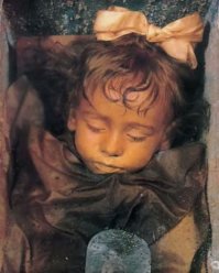 Та же тема есть про церковь, построенную капуцинами в Палермо, Сицилия. Там, среди более чем 2000 мумий, есть одна особенная. Розалии Ломбардо умерла от пневмонии в 1920 году. Ее убитый горем отец нанял бальзамировщика Альфредо Салафия, чтобы сохранить тело двухлетней малышки в первозданном виде. Мастер очень постарался и сделать так, что девочка просыпается каждый день, открывая глаза солнечному свету.

НО... ))
Дело все в том, что веки девочки никогда не были плотно сомкнуты, благодаря чему и создаётся иллюзия открывающихся и закрывающихся глаз в зависимости от угла падения солнечных лучей.

Однако надо конечно признать масткрство бальзамировщика, тело девочки выглядит абсолютно не тронутым временем...