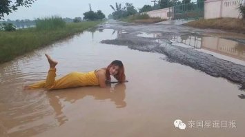 Женщина в Таиланде выибла выбоину на дороге.