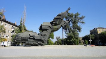 Это образец дебильности памятника, жопорукий архитектор.
По порядку: спереди он нависает над тобой, плюс раскрытый рот. Оч страшно, думаешь, что эта глыба вот-вот упадет. Здесь снимок дальше, но если подойти под самые руки, то жуть.
Вид сзади - картинку найти не смог, но выглядит просто как наваленная куча камней. Нихера не понятно.
Остается один единственный вид сбоку - символизм, но хоть все становится на места.
В народе памятник звался "без пяти семь", поскольку он смотрит на угол дома, где раньше был вино-водочный. Сейчас магазина нет, название забывается.
PS
При всем моем почтении к герою (великий подвиг) к советскому скульптуру Роберту Харитонову теплых чувств не испытываю.