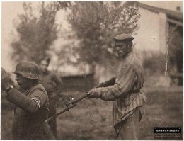 Освобождённый еврей держит нациста под прицелом.