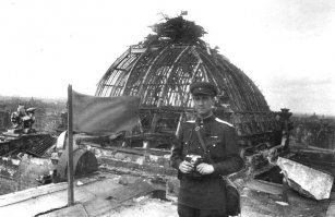 Нашёл всё-таки.
Военный фотокорреспондент газеты Прибалтийского фронта "Вперед на врага" Борис Евгеньевич Вдовенко на крыше рейхстага.

"Борис Вдовенко родился в Ялте в семье почтово-телеграфного механика. В 1911 году его семья переехала в Москву, где в 1926 году, окончанив школу, Борис поступает на работу товарным кассиром железной дороги.

Начиная с 1934 года фотоснимки Б. Е. Вдовенко публиковались в газетах «Правде», «Известиях», «Комсомольской правде», «Вечерней Москве», «Sovietland», «Moscow News», журналах «Огоньке», «Индустрия», «Крестьянка», «Работница», «Journal de Moscou», «Физкультура и спорт» и многих других периодических изданиях. Снимает промышленность, спорт, авиаторов, повседневную жизнь, советскую молодёжь, Красную Армию, персоналии.

В ноябре 1941 года ушёл добровольцем на Великую Отечественную войну. Был фотокорреспондентом фронтовой газеты «Вперёд на врага» Калининского, а затем 1-го Прибалтийского фронта. В декабре 1941 года снимает наступление Красной армии на Калинин, Ржев и Старицу. Во время войны Б. Е. Вдовенко снимал боевые действия: авиации (совершил 29 боевых вылетов в качестве воздушного стрелка), артиллерии, танковых соединений, инженерных войск и пехоты. Снимал он и фронтовой быт, строительство оборонительных сооружений, работу связи и госпиталей, отдых бойцов, а разрушенные города и работ по их восстановлению. Делал Вдовенко и фоторепортажи о жизни тыла: восстановление разрушенных предприятий, напряжённая работа железных дорог, скромный быт рабочих.

По окончании войны Борис Вдовенко продолжил работать в прессе. Его работы печатались в журналах «Огонёк», «Советский Союз», «Крылья Родины», газетах «Советская Россия», «Советская торговля». Много снимал советскую авиацию (военную и гражданскую)."