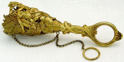 Это милый дамский аксессуар из далёкого и невозвратного элегантного прошлого. Портбукет — это изобретение, введенное в моду в эпоху Людовика XIV. Он представляет собой изящный держатель для живого букета цветов. Помимо эстетства и шика, у портбукета был ещё и практический смысл: эта небольшая вещица питала букет водой, чтобы он подольше выглядел свежим, и помогала прикреплять его к одежде, не пачкая её зеленью и пыльцой, или позволяла удобно держать букет в руках. Портбукет изготавливался из любых материалов: кости, хрусталя, драгоценных металлов — и предназначался как для украшения одежды, так и сам по себе мог служить отдельным аксессуаром.