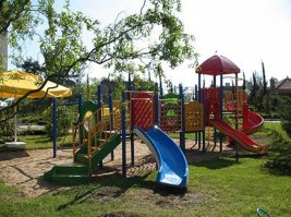 М-да...статейка...Интересно, у аффтыря дети есть? Или, хотя бы, он видит разницу между ребенком 3-х лет и 12-ти? Все вот эти супермегаплощадки с канатами, переходами и всем прочим, которыми он так восхищается - если туда запустить 3-5-летнего малыша, он хоть жив-то там останется? Школьникам-то да, будет интересно и весело, а малышам? Безопасность-то он как, гарантирует? Что никто ниоткуда не упадет и не разобьется?
И не понимаю, чем ему плох владивостокский корабль-площадка? Я такой у тети в Югорске во дворе видела. И вот как раз он по нраву и школьникам, и малышам, я там своего четырехлетку успешно выгуливала.
А яркие цвета чем насолили? Товарищ, видимо, в Сочи живет, где каждый год - буйство красок. А есть еще средняя полоса и - вот чудеса! - Север, где круглый год или потемки, или хмарь. Конечно, туда тоже надо впихнуть что-нибудь неброское, в серо-коричневых тонах, чтоб мигрень у детишек, боже избави, не сделалась.
Вот, например, детская площадка в санатории "Шексна", мы летом там отдыхали. И что в ней плохого?