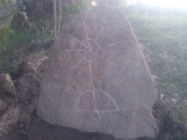 На въезде в деревню стоит такой камень. Знает кто, что на нем написано? Что за символ?