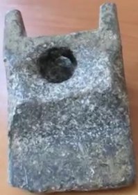 Аюдский артефакт

Это событие произошло в 1974 году в Румынии, двумя километра восточнее города Аюд. Группа рабочих, работавшая на берегу реки Марош, в расселине, заполненной песком, на глубине 10 метров обнаружила три объекта. Два объекта были костями давно вымерших мастодонтов, а третий объект оказался куском металла. По форме он напоминал клин и имел несколько отверстий. Размеры артефакта составляли 20,1 см в длину, 12,7 см в ширину и 7 см в высоту, а вес - 2,3 кг.

Анализ этого артефакта показал, что он является сложным сплавом из 12 различных элементов, основным из которых является алюминий - его содержится 89% по объёму. Остальные 11% составляют медь, кремний, цинк, свинец, олово, цирконий, кадмий, никель, кобальт, висмут, серебро. Так же в очень небольших количествах в артефакте были обнаружены следы галлия. Полный состав сплава приведён в таблице.

состав:
Материал	%
Алюминий	89
медь	6,2
кремний	2,84
цинк	1,81
свинец	0,41
олово	0,33
цирконий	0,2
кадмий	0,11
никель	0,0024
кобальт	0,0023
висмут	0,0003
серебро	0,0002

Сверху Аюдский объект покрыт толстым слоем оксидной плёнки, что свойственно для алюминия. Если древность этого артефакта определять по толщине оксидной плёнки, то Аюдскому объекту должно быть по меньшей мере 300 или 400 лет.

На Аюдском объекте имеются явно выраженные следы механической обработки - в левом выступе просверлено отверстие, а в середине объекта присутствуют два сообщающихся канала.

Это очень странно, что такой металлический объект был найден вместе с костями мастодонта. Одни считают этот объект доказательством древнего палеовизита инопланетных астронавтов. Другие считают, что Аюдский объект - это свидетельство существования технически развитой працивилизации. Большинство учёных же полагают, что Аюдский объект - это либо мистификация, либо просто имела место ошибка в его датировке, так как впервые алюминий был получен только в 1825 году.