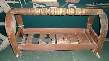 Почему только в Непале? И на Кавказе.
  В прежние времена на дно люльки укладывался плотный матрац из соломы или овечьей шерсти, и обязательно имелось отверстие, в которое укреплялась трубчатая кость для стока мочи в сосуд . Тело ребенка привязывалось двумя широкими поясами или лентами, на концы которых прикреплялись тесемки, которые проводили под колыбелью и туго завязывали на перекладине колыбели. Такой способ пеленания использовался раньше и применяется до сих пор народами Северо-Восточного Кавказа: чеченцами, ингушами и народами Дагестана.